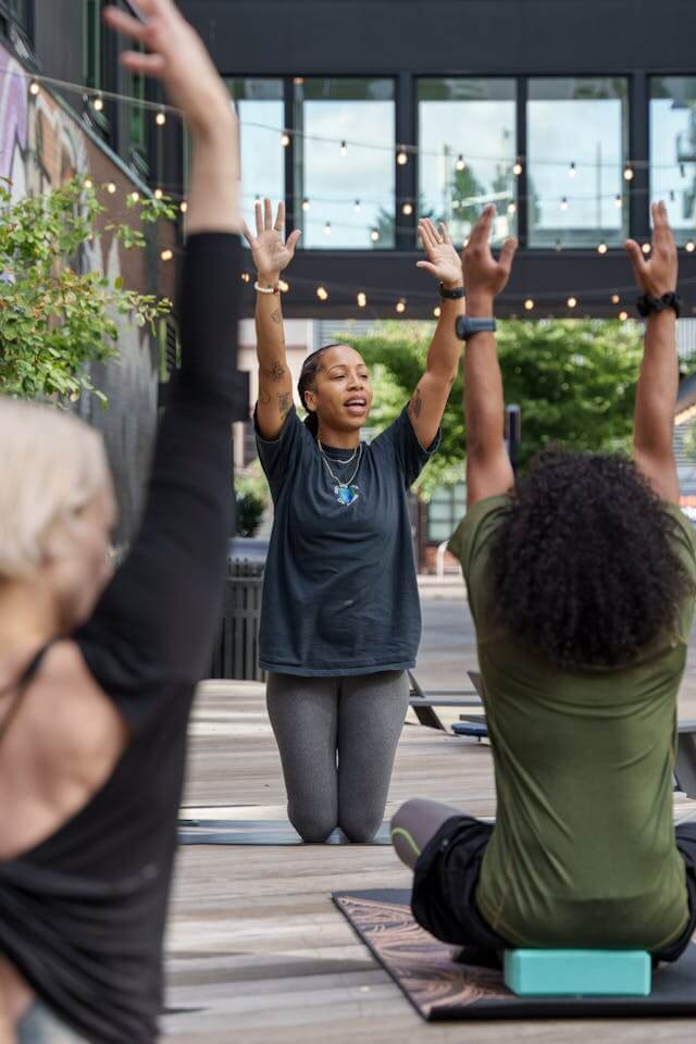 yoga teacher in outdoor garden teaching a class of 4 people