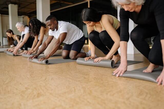 7 people in a yoga studio posing on a mat
